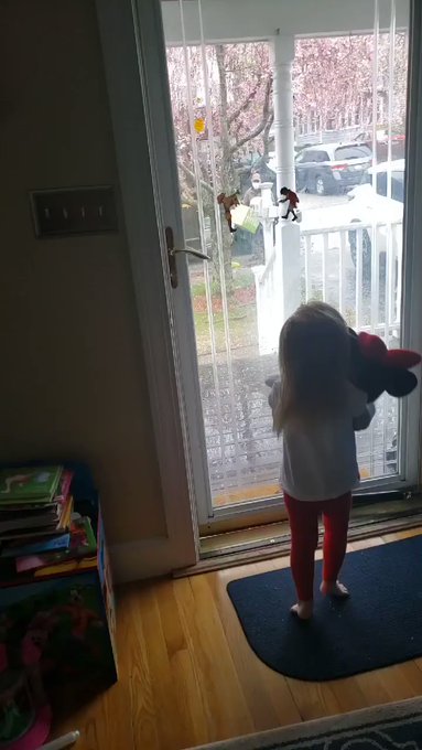 Menina de 2 anos aguarda entregador para acenar pela janela